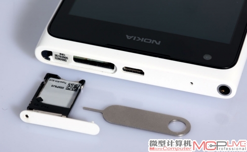 Lumia 900 Micro SIM卡卡槽隐藏在机身顶部，需要借助取卡针才能把卡托取出来。使用取卡针时不要用太大力，避免卡针折断。